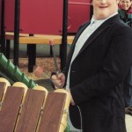 Young man plays adapted instrument in an inclusive playground