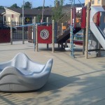 children with autism enjoy the omni spinner in this accessible playground